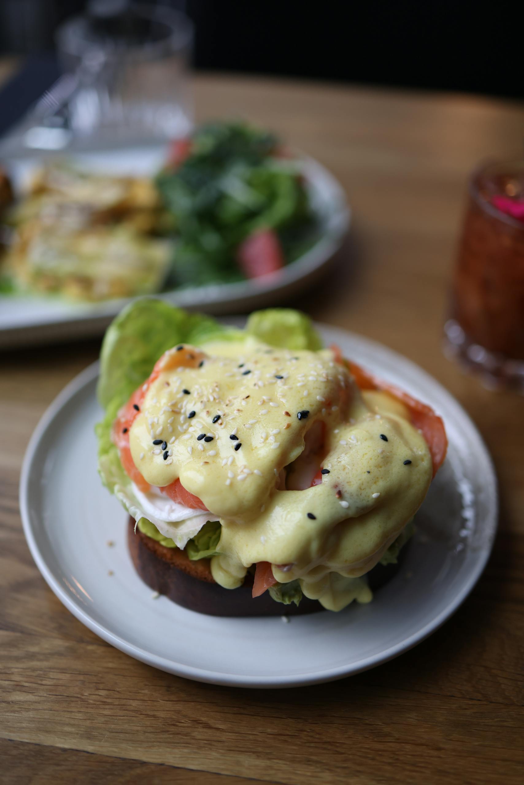 Delicious eggs benedict with creamy hollandaise sauce and sesame seeds.